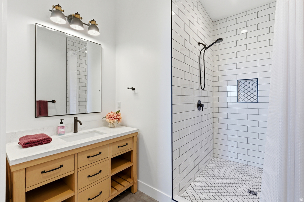 Modern bathroom featuring a wood-finish vanity with a light-toned countertop, a rectangular sink, and matte black fixtures