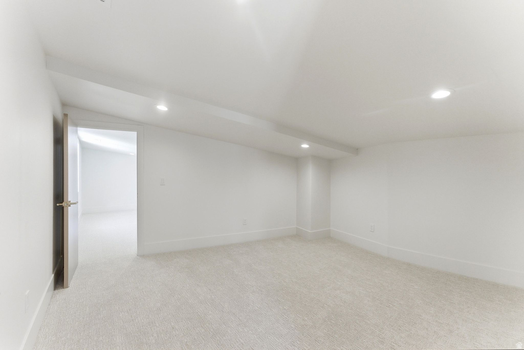 Bright, neutral-toned room featuring light-colored carpeting and recessed lighting
