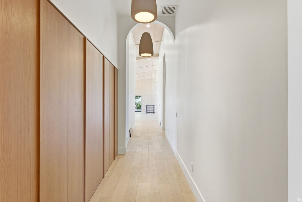 Long hallway with light wood-finish flooring