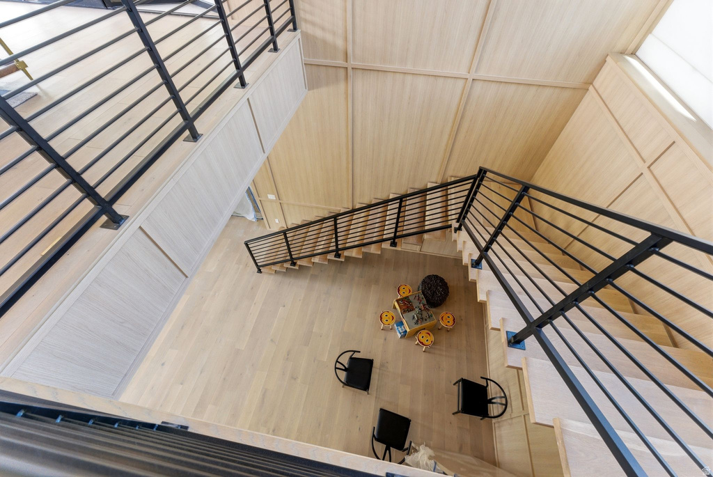 Multi-level interior featuring light wood-finish flooring and paneling, complemented by contemporary black metal railings