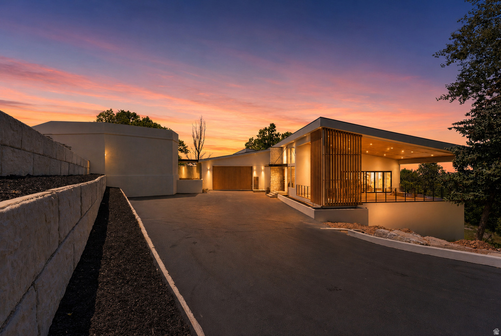 Modern architectural design featuring a cantilevered roofline, wood slat accents, and a spacious covered patio