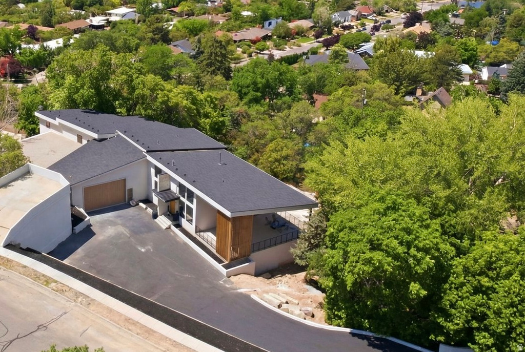 Contemporary architectural style with a dark shingle roof, extensive vertical window arrays, and a wood-finish garage door