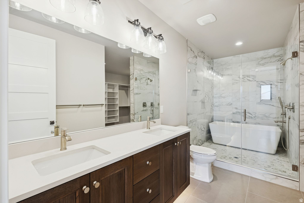 Bathroom featuring a dual vanity with white countertops and dark wood cabinetry, a frameless glass shower enclosure, a freestanding soaking tub, and marble-look tile walls