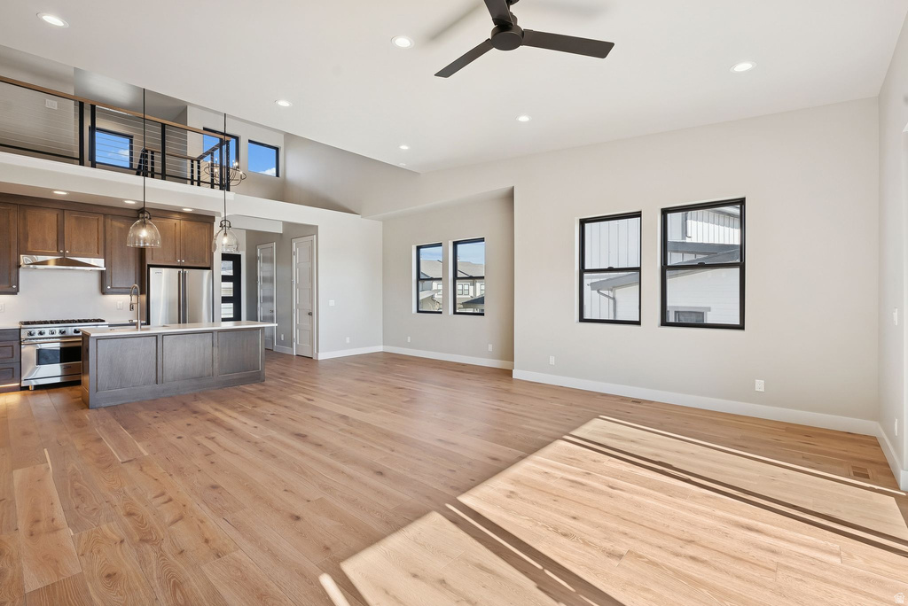 Open-concept living space featuring wood-finish flooring, a contemporary kitchen, and a vaulted ceiling