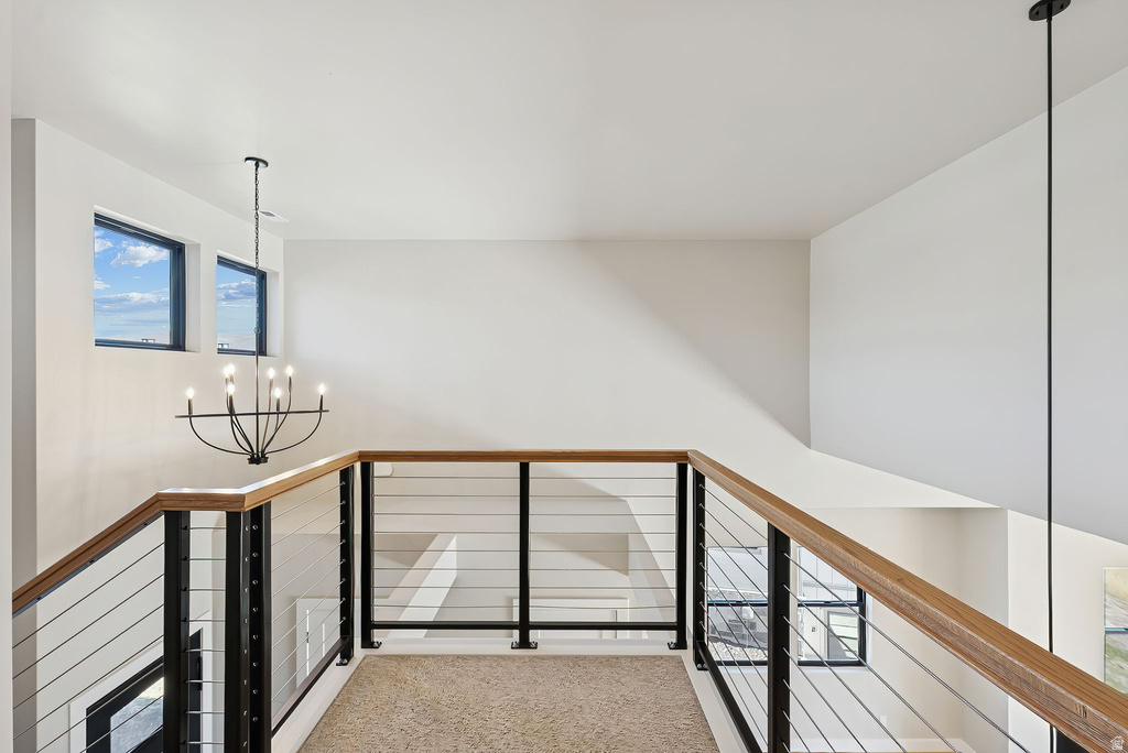 Loft area featuring a modern cable railing system with wood-finish handrails and black metal posts