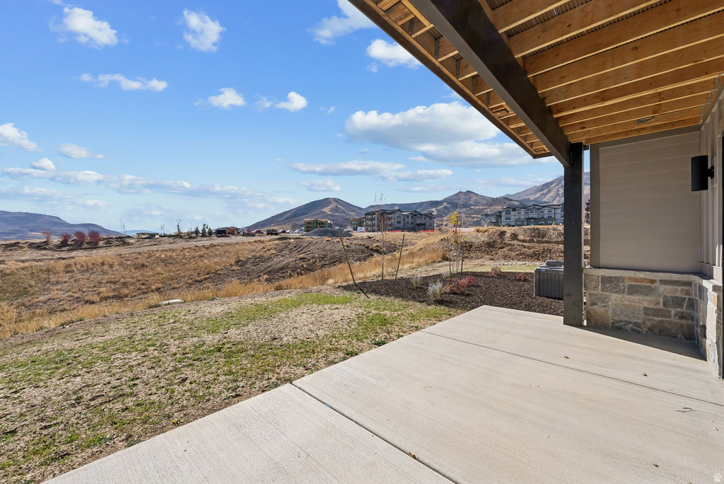 Covered patio featuring a concrete slab and exposed wood ceiling joists