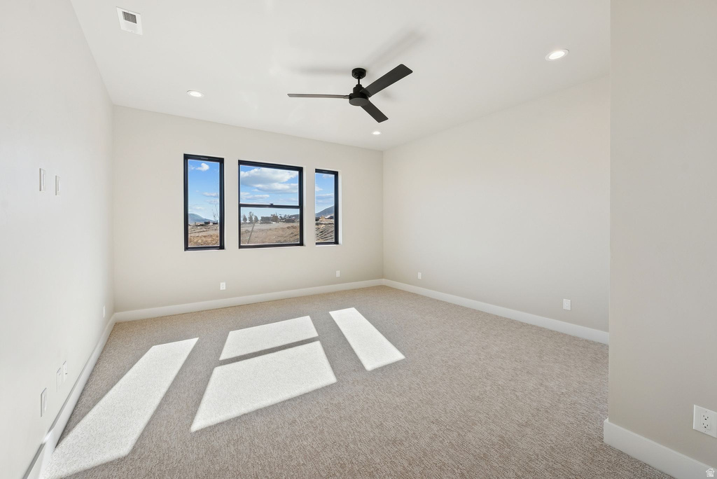 Room featuring three black-framed windows, a black ceiling fan, recessed lighting, and light-colored carpeting