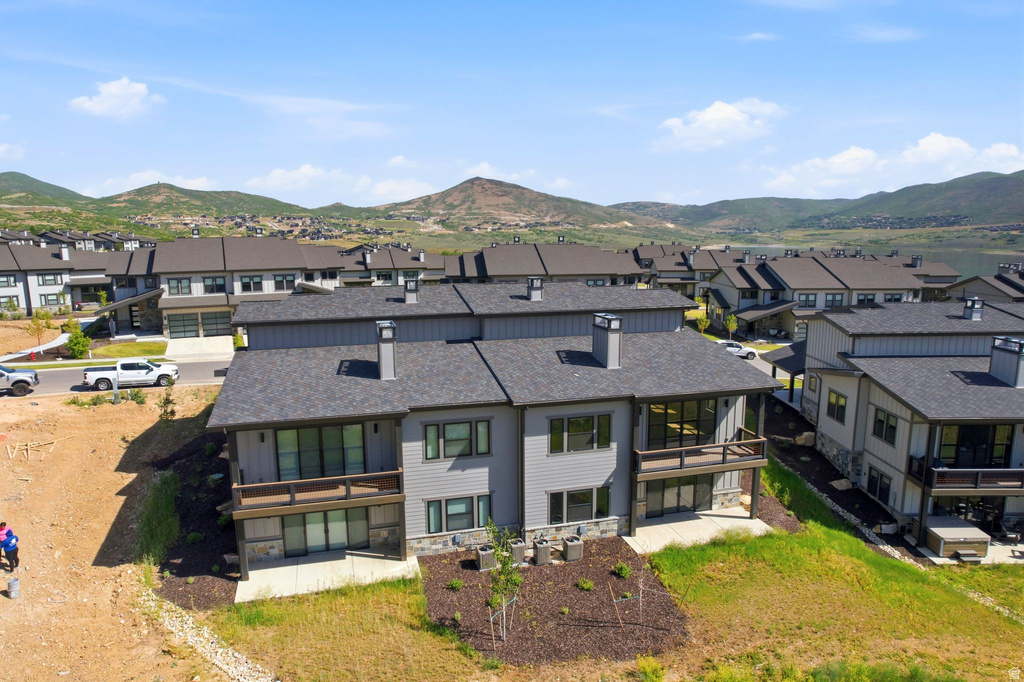 Modern multi-level residence featuring gray siding, dark trim, and a shingled roof