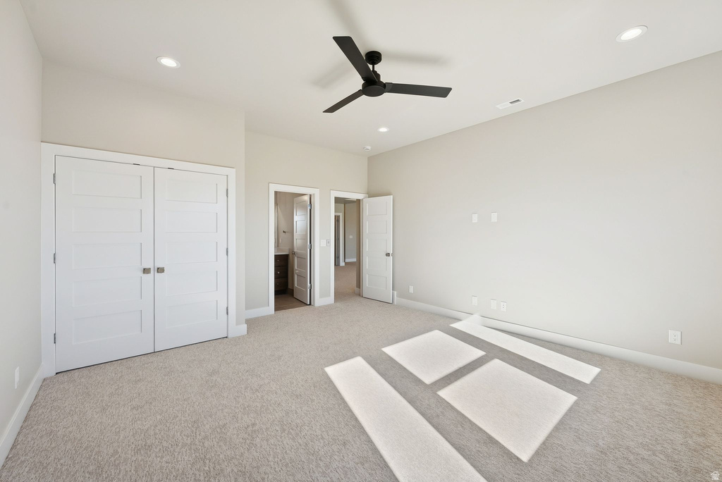 Spacious room featuring neutral carpeting, recessed lighting, and a modern black ceiling fan