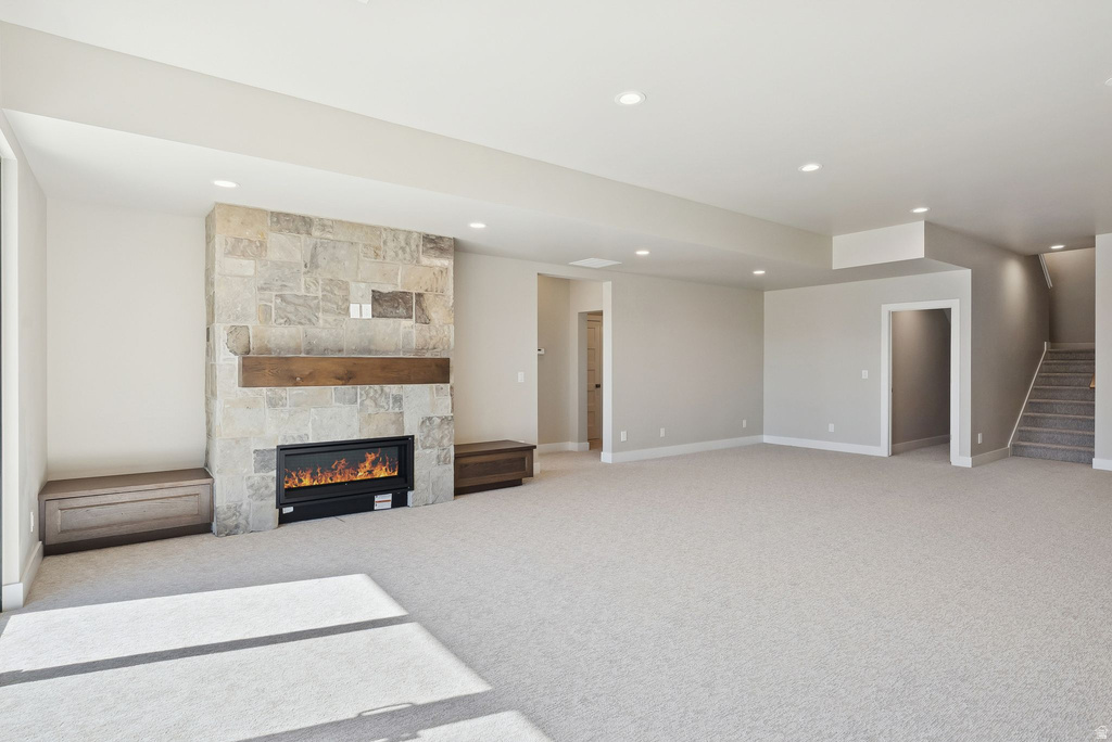 Spacious interior featuring a stacked stone fireplace with a substantial wood mantel, integrated electric fireplace, and recessed lighting