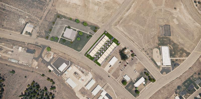 Aerial view showcasing a rectangular multi-unit residential complex with individual parking spaces