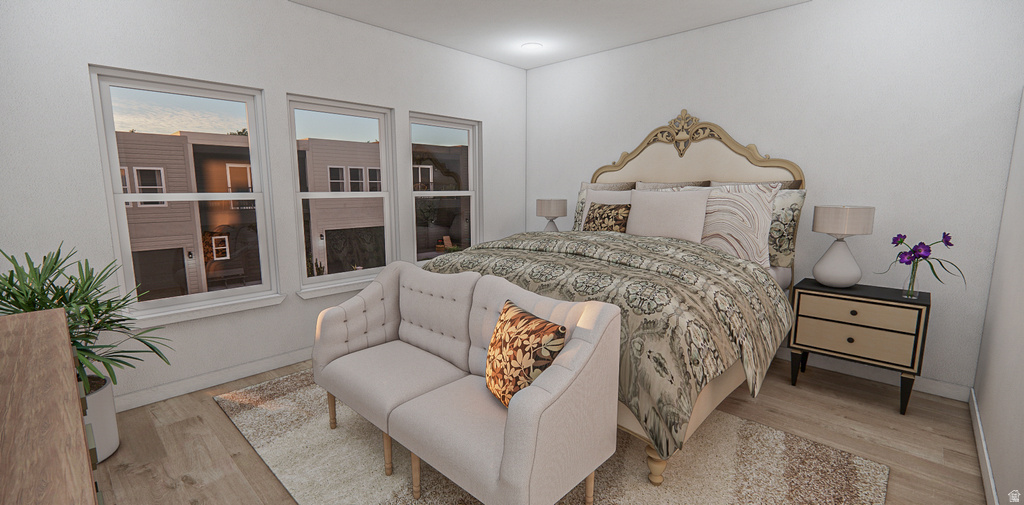 Spacious bedroom featuring light wood-finish flooring and three large windows