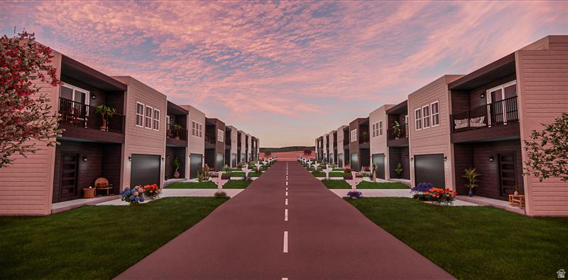 Modern townhome community featuring a uniform architectural design, individual garages, private balconies, manicured lawns, and a central paved roadway