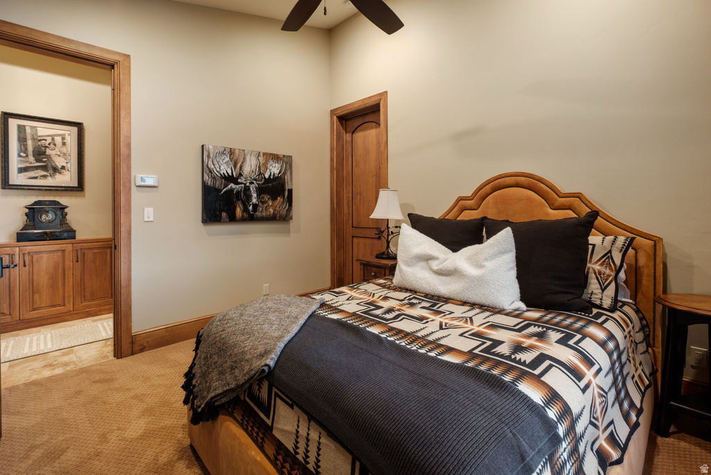 Carpeted room featuring a ceiling fan, light-colored walls, and wood trim