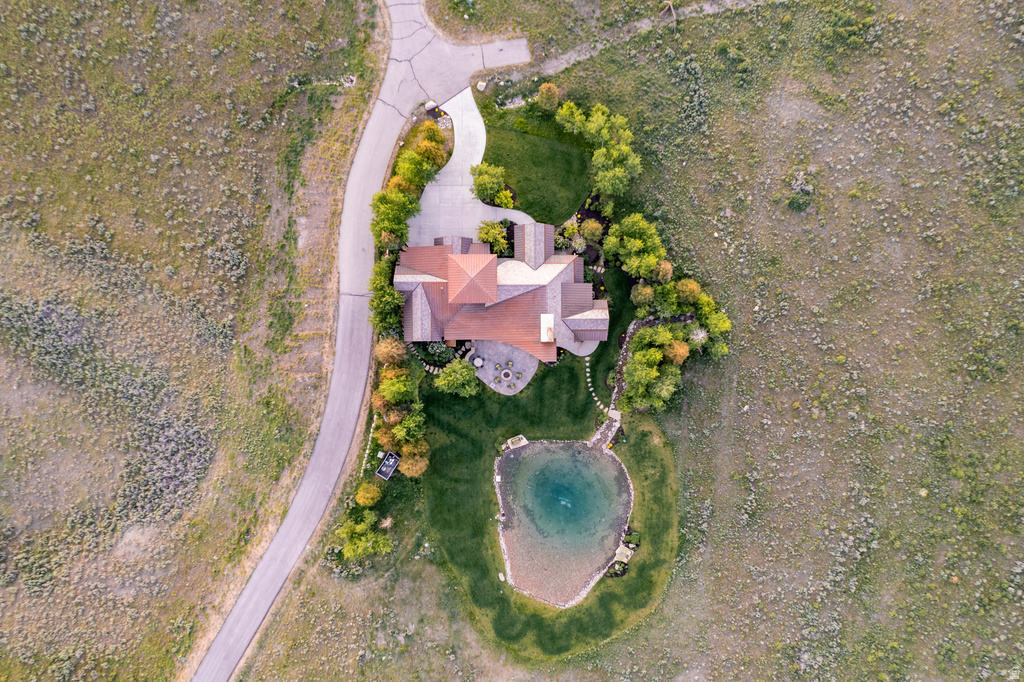 Expansive property featuring a multi-level roofline, a private pond, and varied landscaping