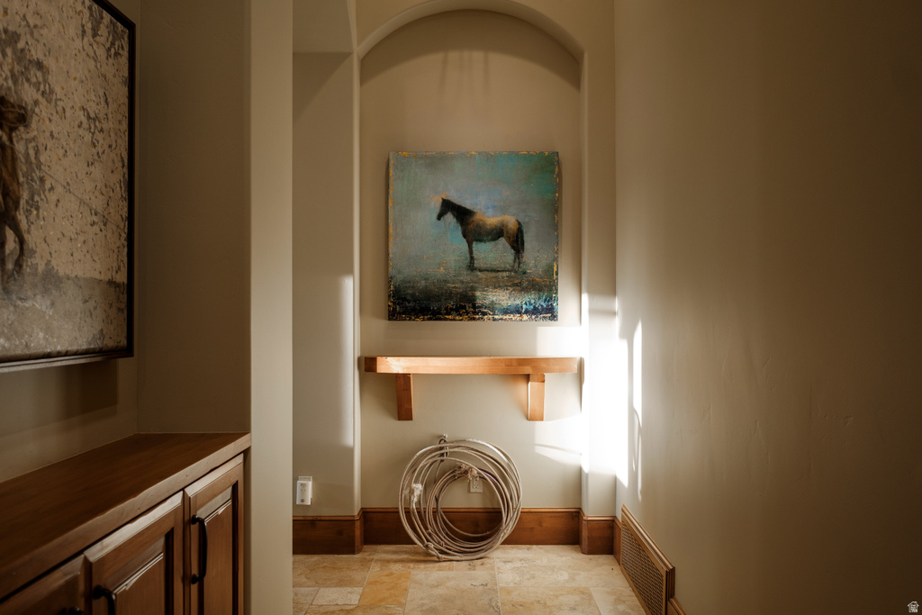 Arched wall niche featuring a wood shelf