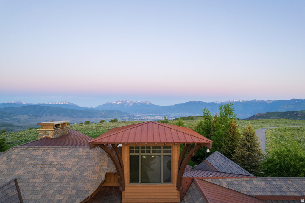 Striking roofline with a copper-colored metal roof accenting a dormer window, complemented by asphalt shingle roofing