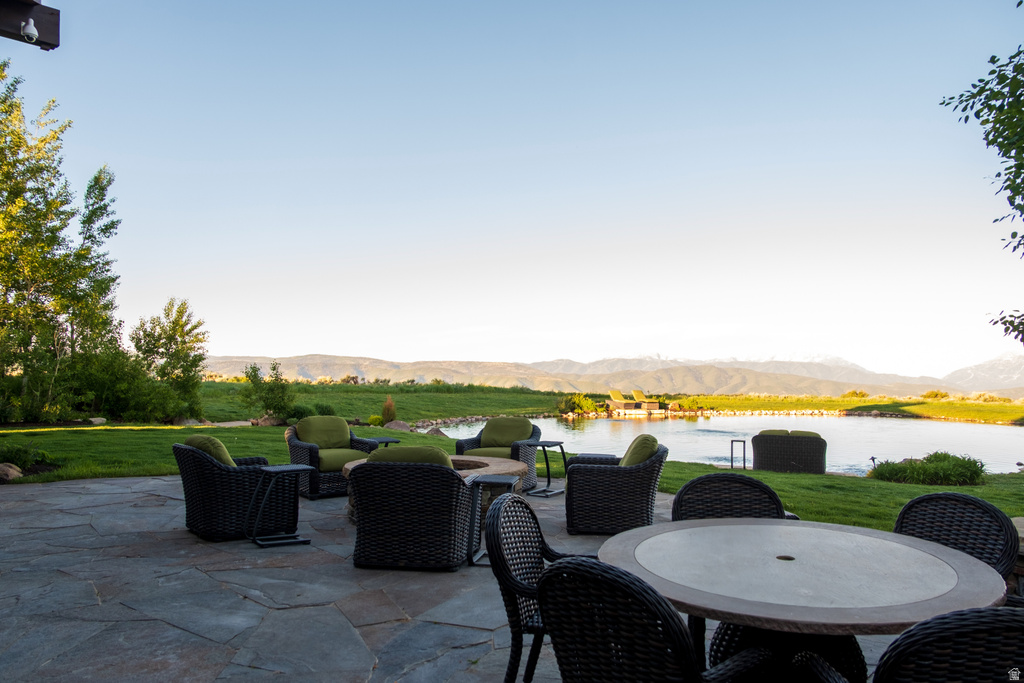 Expansive flagstone patio overlooking a tranquil pond with a fountain