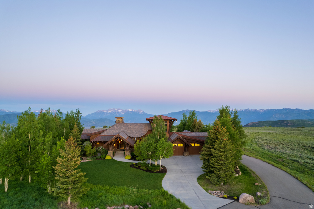 Mountain-style residence featuring a prominent stone chimney and a multi-level architectural design