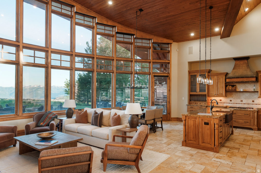 Great room featuring expansive, multi-story windows, wood-finish vaulted ceilings, and tile flooring