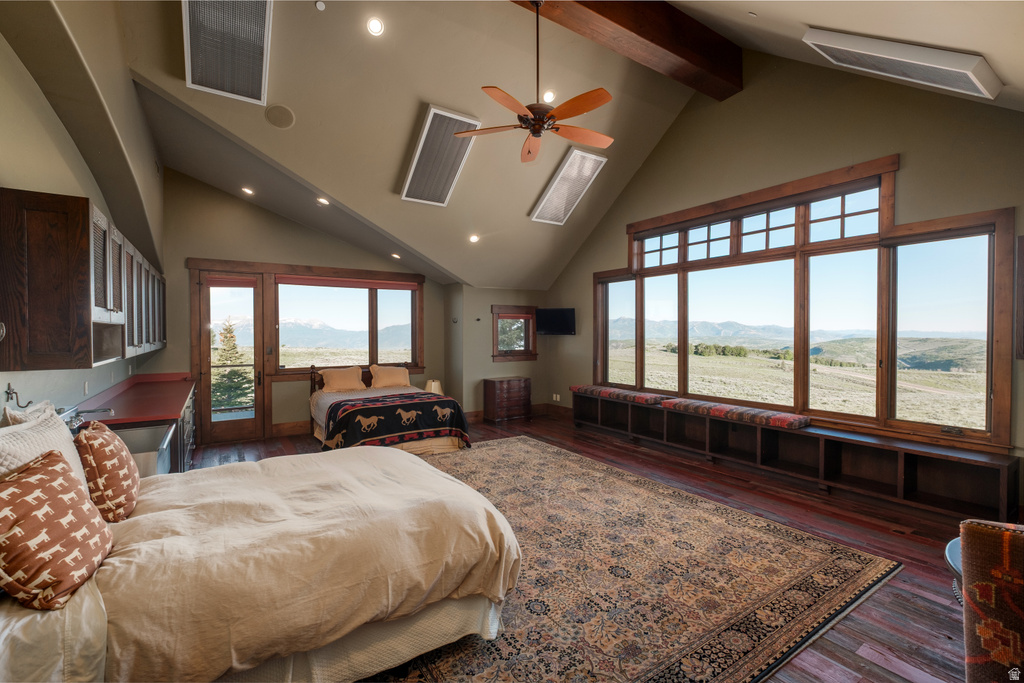 Spacious room featuring vaulted ceilings with exposed wood beams, recessed lighting, and a ceiling fan