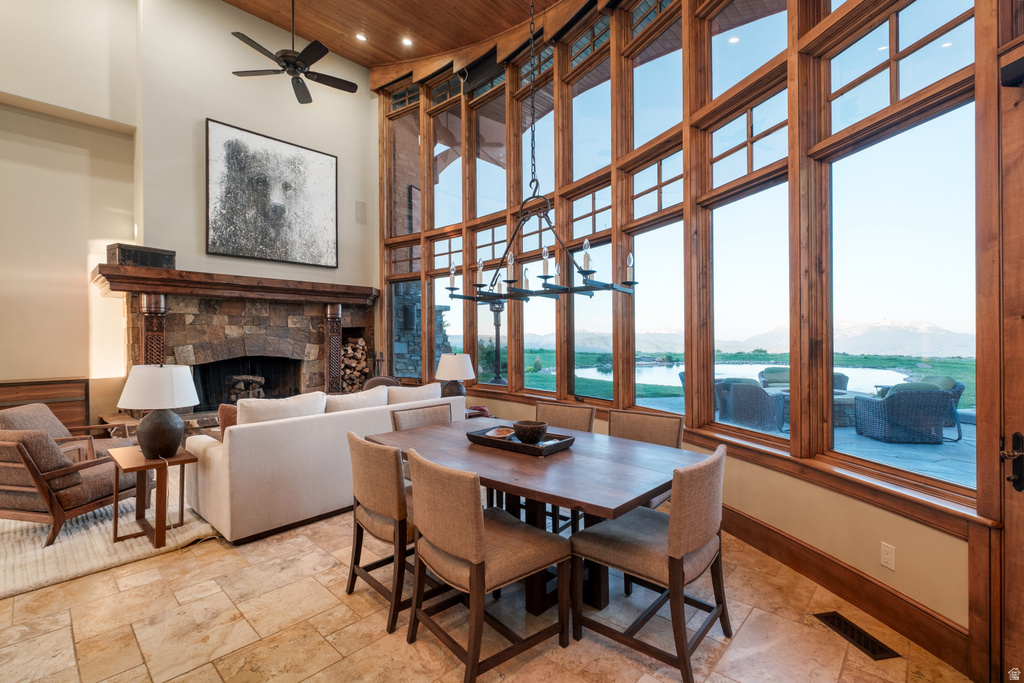 Expansive living space featuring a stone fireplace with a substantial wood mantel, soaring ceilings, and a wood-finish ceiling