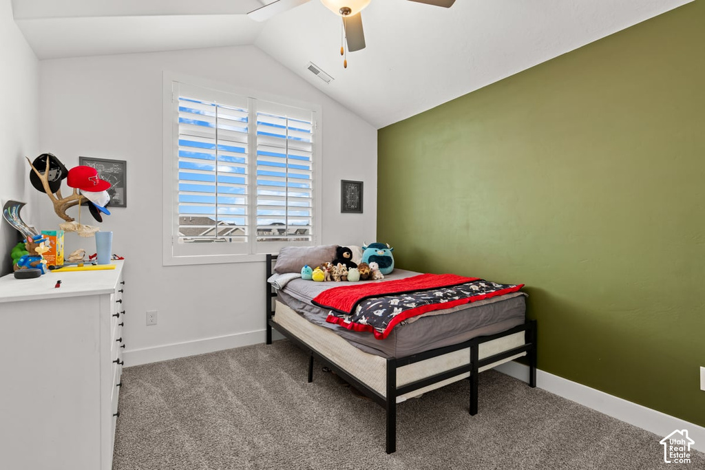 Room featuring an accent wall, plush carpet, and vaulted ceiling