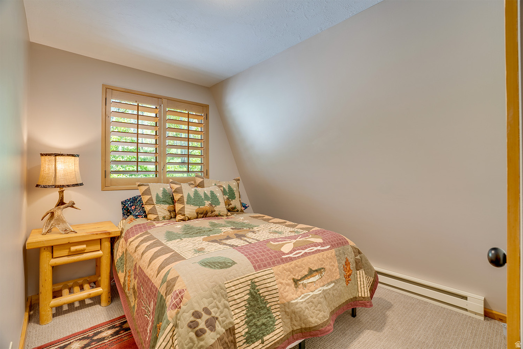 Carpeted room featuring a window with natural wood plantation shutters