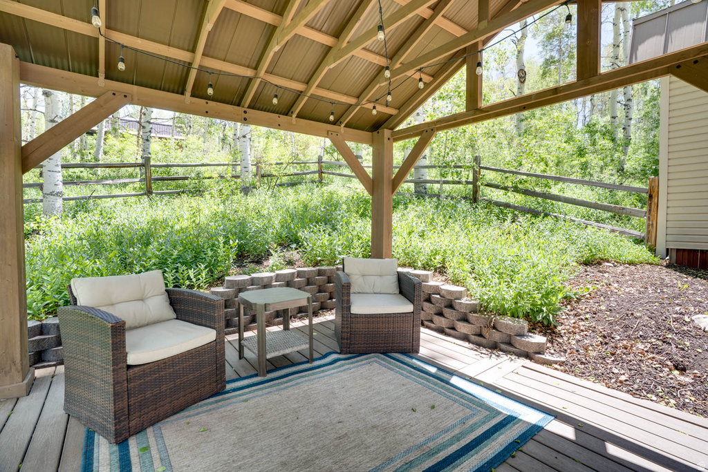 Covered outdoor deck area with exposed wood beams and a corrugated metal roof