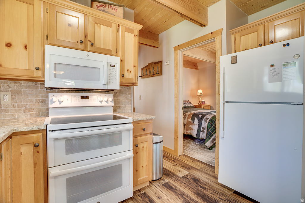 Kitchen featuring wood-finish cabinetry, light-toned countertops, a white double oven range, and an over-the-range microwave