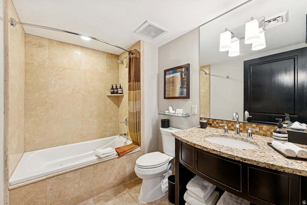 Bathroom featuring a built-in bathtub with integrated shower, stone-tiled surround, and a wall-mounted shower head