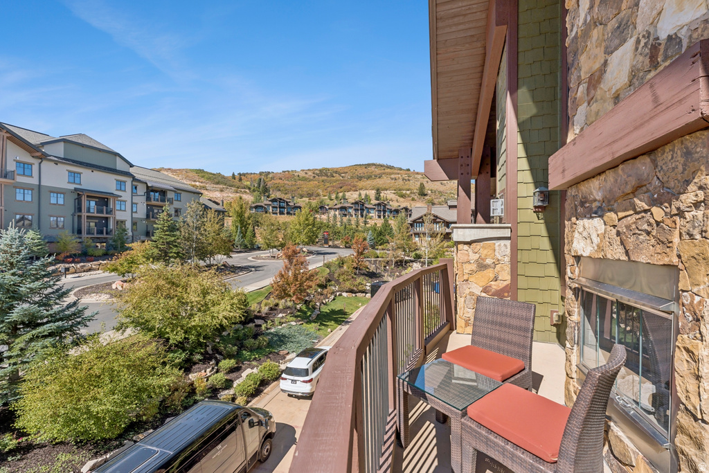 Private balcony with stone exterior wall and wood railing