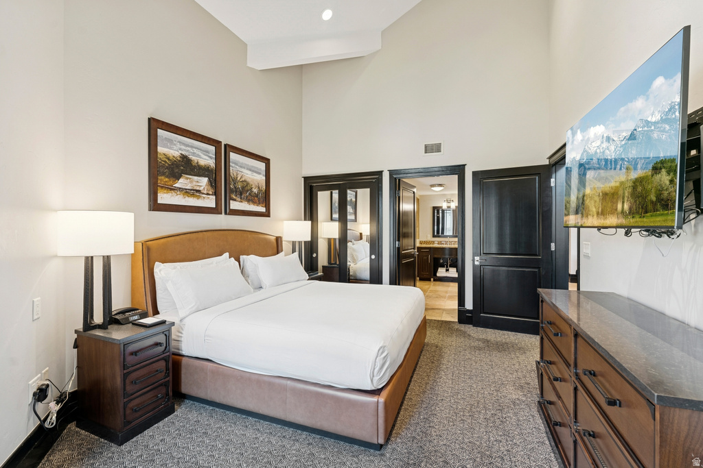 Bedroom featuring vaulted ceilings and textured carpeting