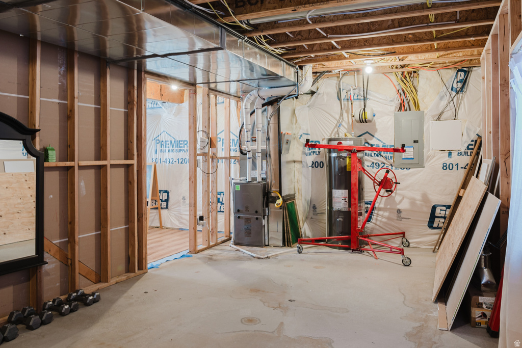 Unfinished basement space featuring exposed wooden framing, concrete flooring, and visible electrical wiring
