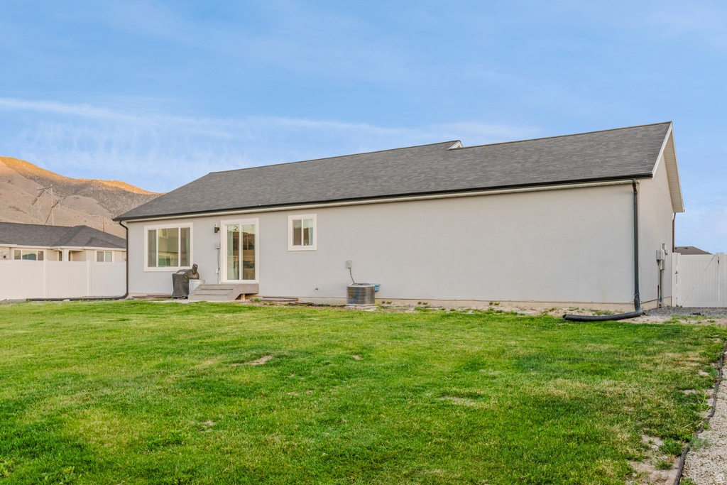 Expansive green lawn with a white privacy fence