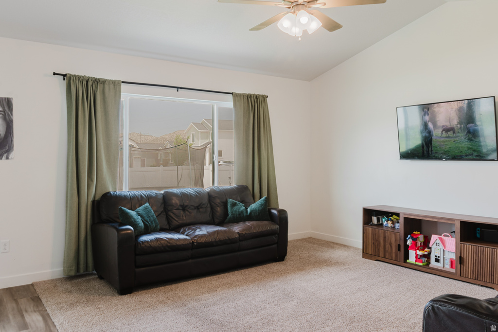 Spacious room featuring a vaulted ceiling and a ceiling fan with integrated lighting