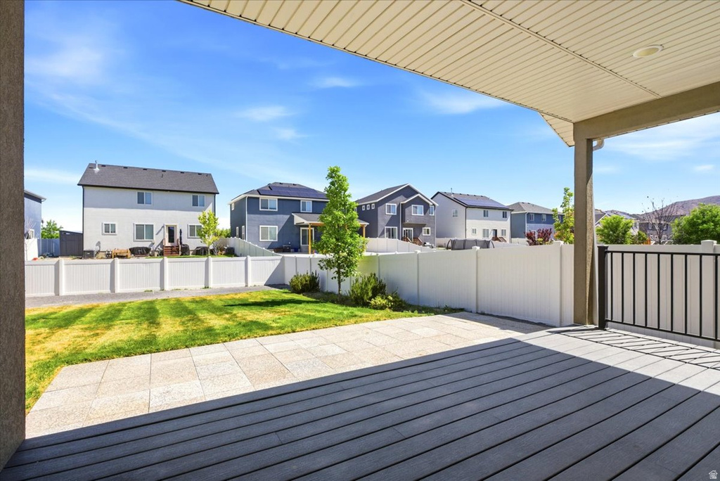 Spacious covered deck featuring composite decking and black metal railings