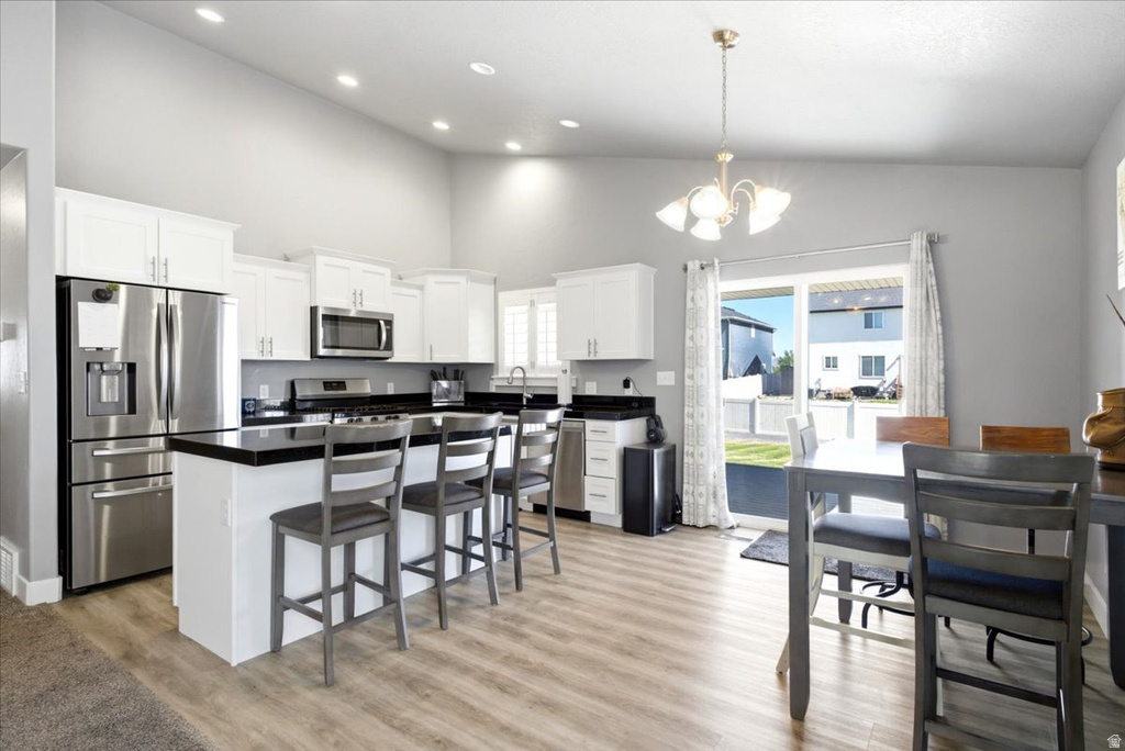Kitchen and dining area featuring vaulted ceilings with recessed lighting