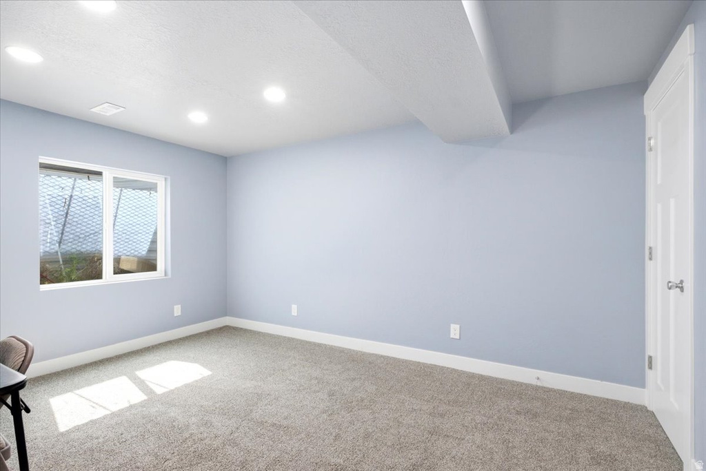 Carpeted room featuring a white-framed window, recessed ceiling lighting, light blue walls, and white baseboards