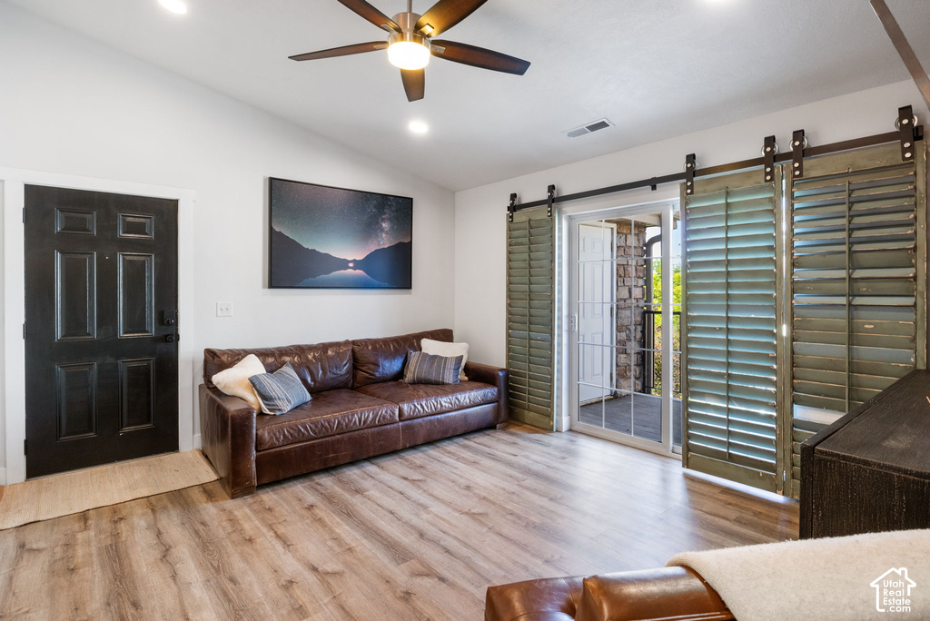 Living area featuring wood-finish flooring, a vaulted ceiling, and recessed lighting