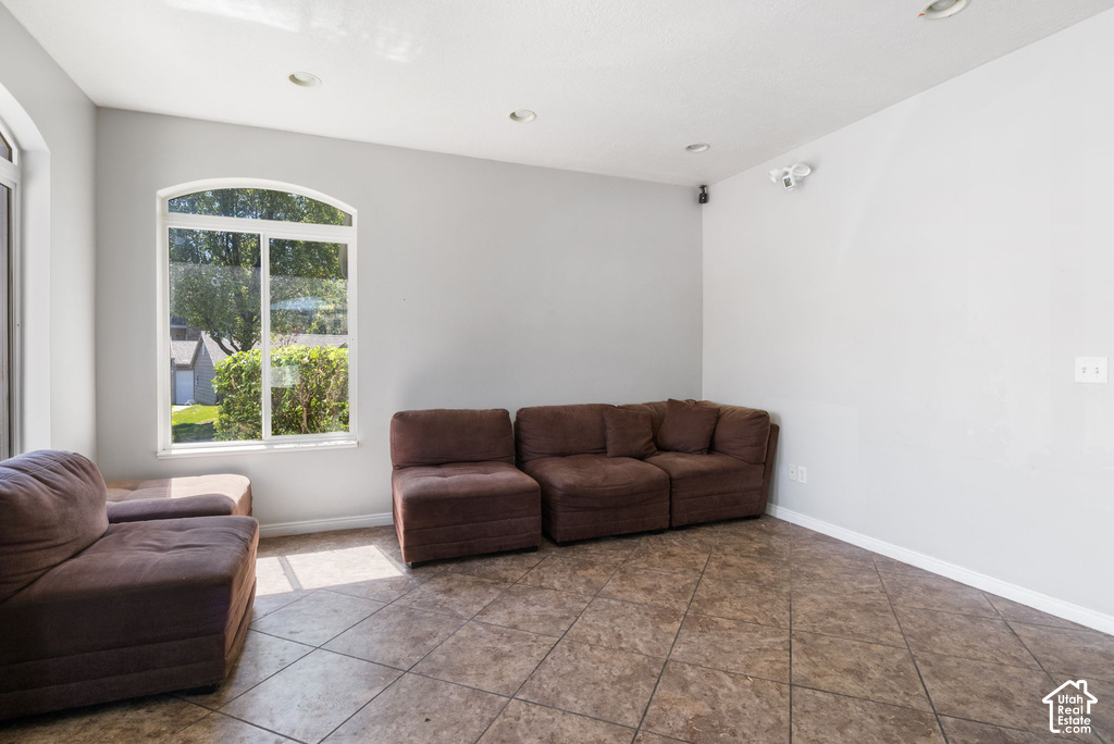 Spacious room featuring light gray walls, recessed lighting, and tile flooring