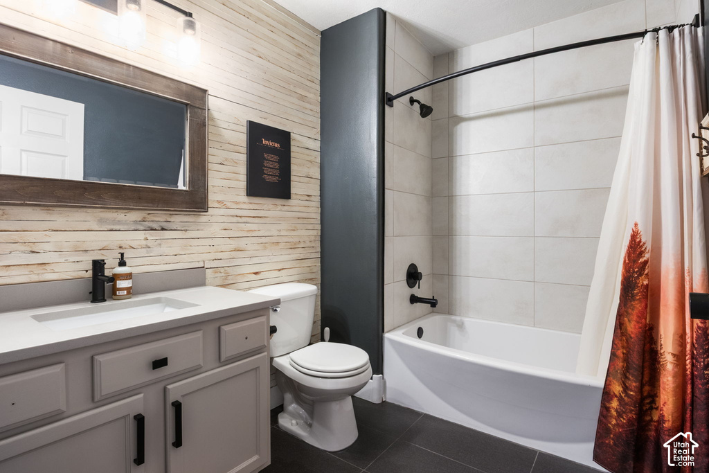 Bathroom featuring a light wood-paneled accent wall, a white vanity with a light countertop and black hardware, a black-framed mirror, and a full-size bathtub with white tile surround and matte black fixtures