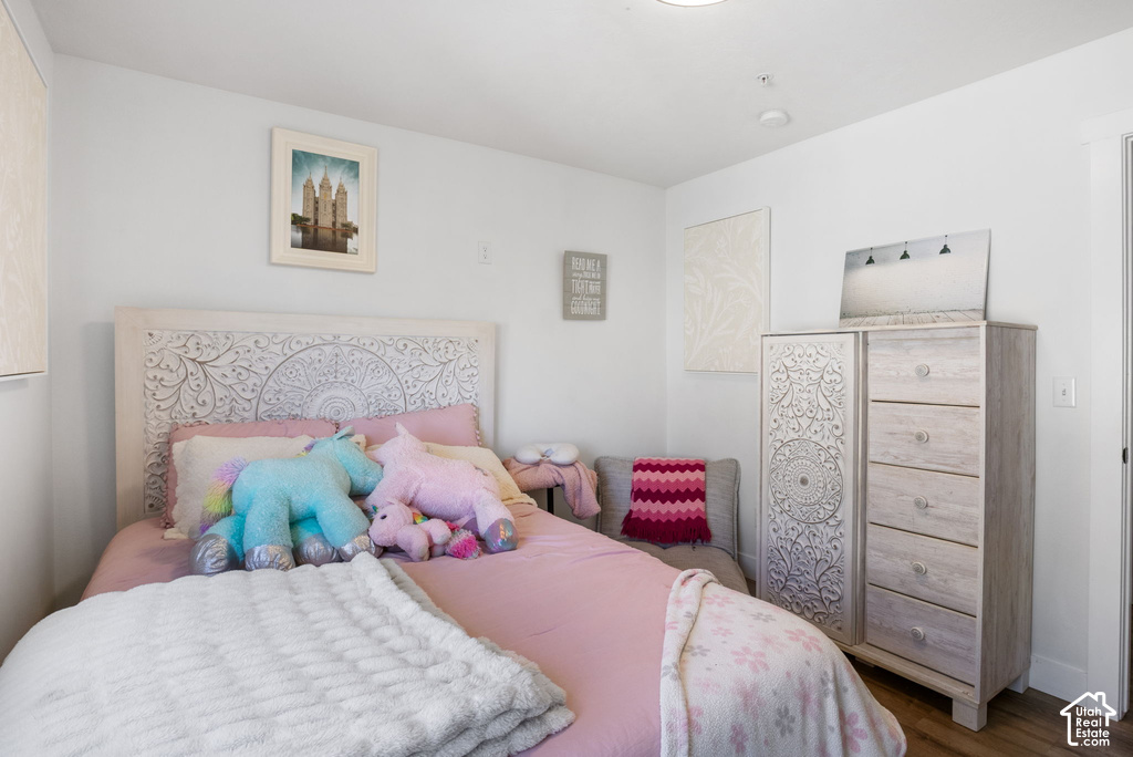 Bright bedroom featuring light-toned wood-finish flooring and white walls