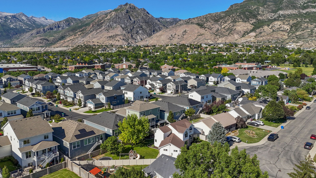 Residential neighborhood featuring a variety of architectural styles, mature trees, and a mountainous backdrop