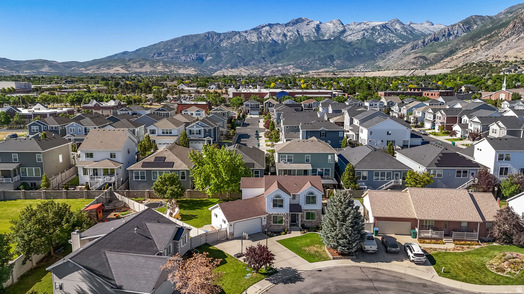 Residential neighborhood featuring a variety of single-family homes with pitched roofs and mature landscaping, set against a backdrop of snow-capped mountains