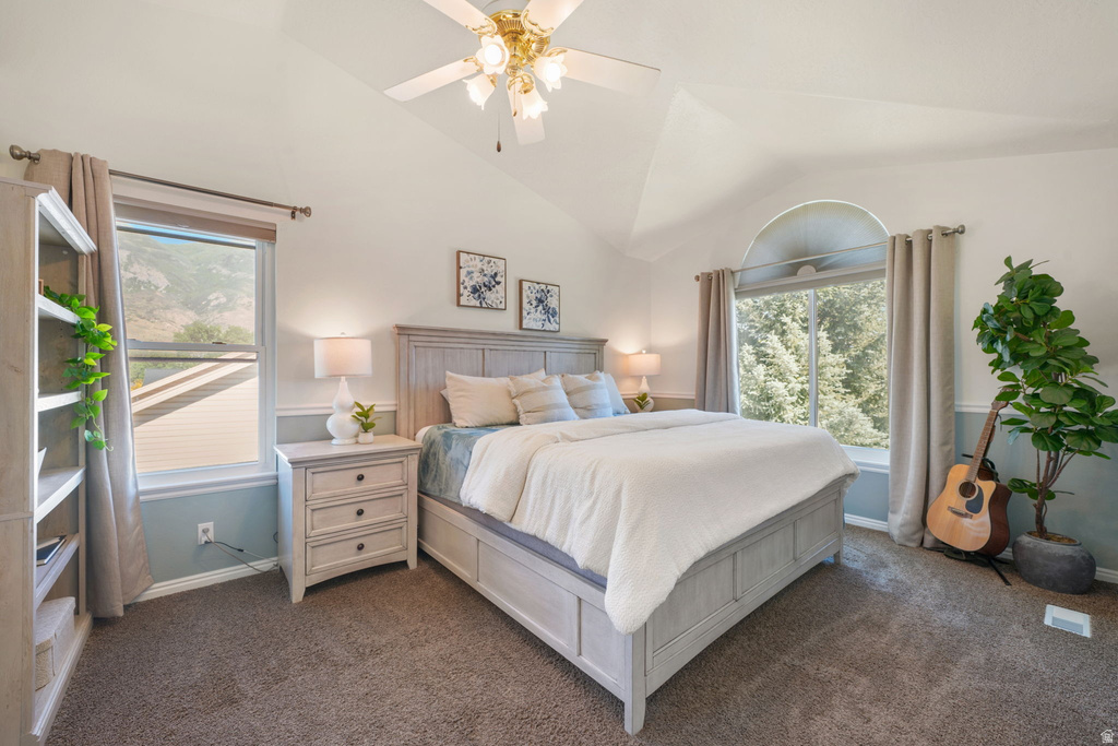 Carpeted bedroom featuring vaulted ceilings, a ceiling fan, and architectural windows