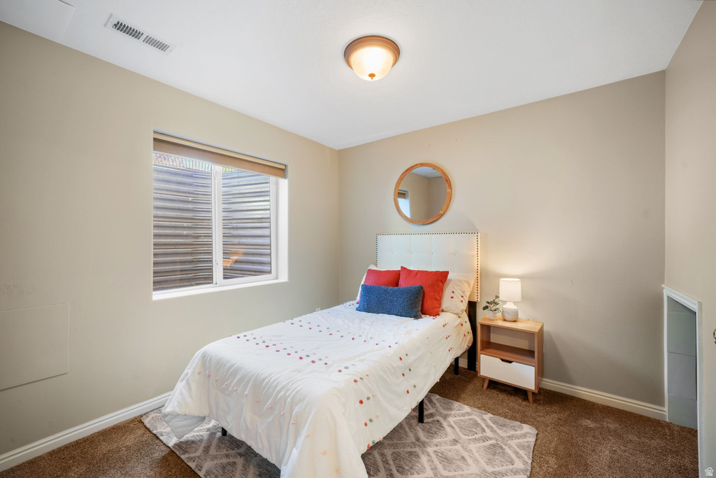 Carpeted room featuring a single window and a ceiling-mounted light fixture