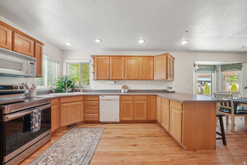 U-shaped kitchen featuring wood-finish cabinetry and countertops
