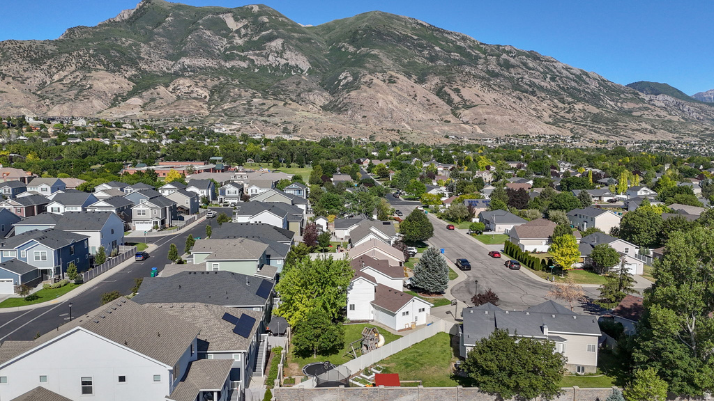 Residential neighborhood with a mountainous backdrop, featuring a variety of single-family homes and mature trees