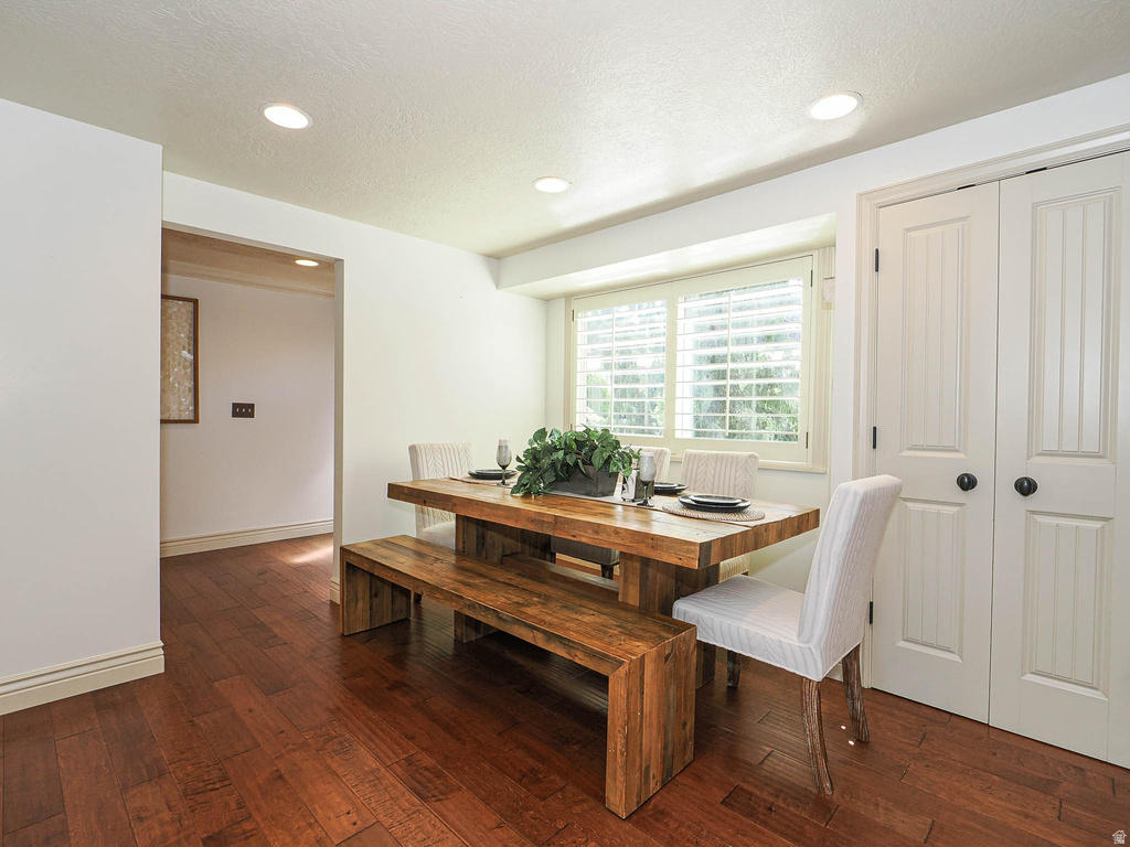 Dining area featuring rich wood-finish flooring, recessed lighting, and a window with plantation shutters